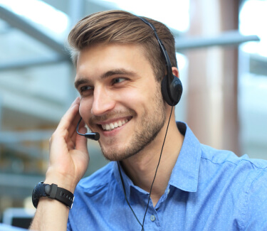 Male receptionist in blue shirt wearing headset